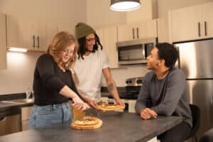 Residents making pizza together in an apartment kitchen