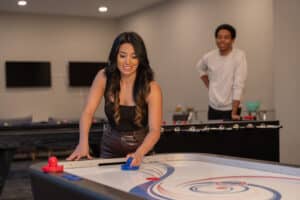 Residents playing air hockey in a game room