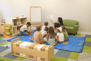 Teacher reading to children seated on a rug in a classroom